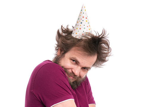 Shy bearded Man with funny Haircut in birthday cap, isolated on white background. Happy guy smiling and looking at camera. Holidays, Emotions and Signs concept.