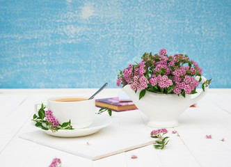 Summer morning. Breakfast. Cup of Coffee with bouquet of Spiraea japonica flowers. Greeting for Birthday or Holiday. Copy space