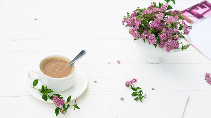 Summer morning. Breakfast. Cup of Coffee with bouquet of Spiraea japonica flowers. Greeting for Birthday or Holiday. Copy space