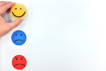 Happy, sad and angry face icons in white background. Hand choosing happiness. Customer satisfaction and feedback concept.