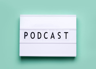 lightbox white board on a mint color background with the words podcast