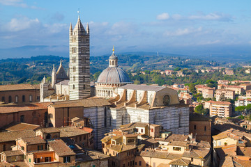 Scenery of Siena, a beautiful medieval town in Tuscany, with panoramic view of the Dome and Bell Tower of Siena Cathedral (Duomo di Siena), landmark Mangia Tower, Italy