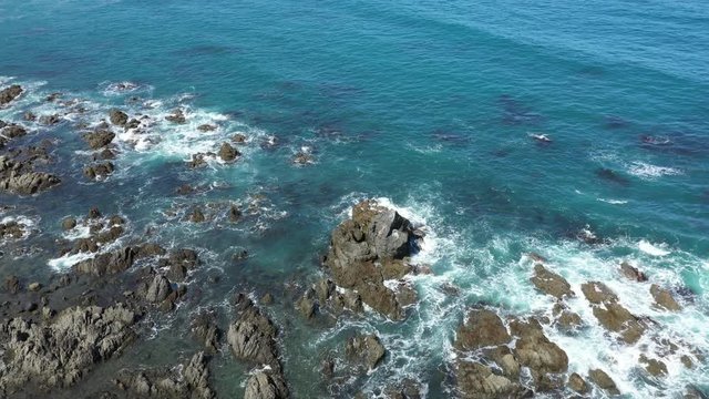 Aerial footage of rocks and beach in Wellington, New Zealand