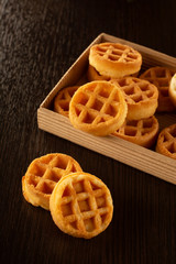 Waffle round-shaped biscuits on the table in a box