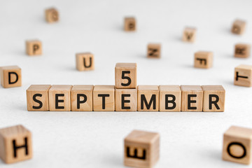 September 5 - from wooden blocks with letters, important date concept, white background random letters around