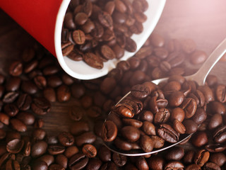 Coffee beans poured from a red plastic Cup