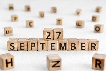 September 27 - from wooden blocks with letters, important date concept, white background random letters around