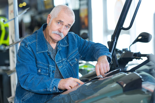 senior man checking motorbike