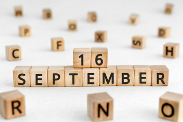 September 16 - from wooden blocks with letters, important date concept, white background random letters around