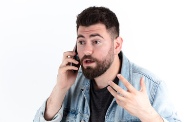 young man speaking by the phone. confused and angry facial expression