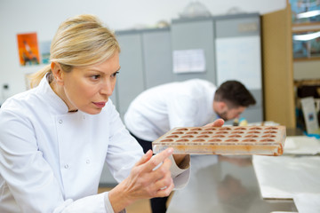 female chocolatier looking at chocolate mold