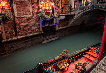 moored gondola on narrow canal with bridge and christmas lights  © C A Creative