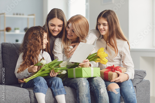 Happy Mother's Day. Children daughters give mom a bouquet of flowers at home.