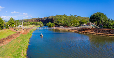 Obraz premium Aerial drone view of the wooden swinging bridge of Hanapepe over the river on Kauai