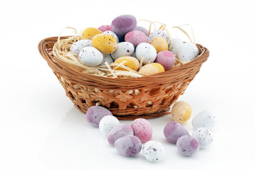 Easter candy in a basket isolated on white