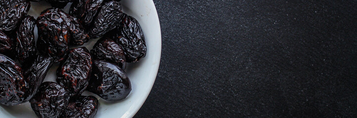 prunes, dried plums (tasty and healthy fruits) desiccated keto or paleo diet menu concept. background. top view. copy space