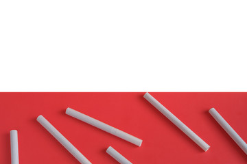 Scattered cigarettes on a light pink background, symbolizing the dangers of smoking.