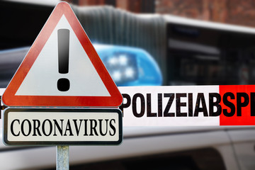 Coronavirus - Verkehrschild vor Polizeiabsperrung