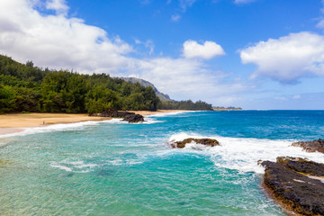 Aerial panoramic image off the coast over Lumaha'i beach on Hawaiian island of Kauai with Na Pali mountains behind