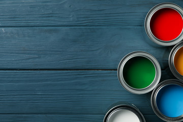 Paint cans on wooden background, space for text