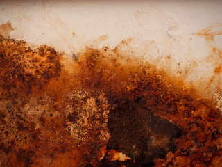 Brown, black and yellow rust on white enamel. Rusted brown and white abstract texture. Corroded white metal background. Rusted white painted metal wall. Rusty metal surface with streaks of rust.