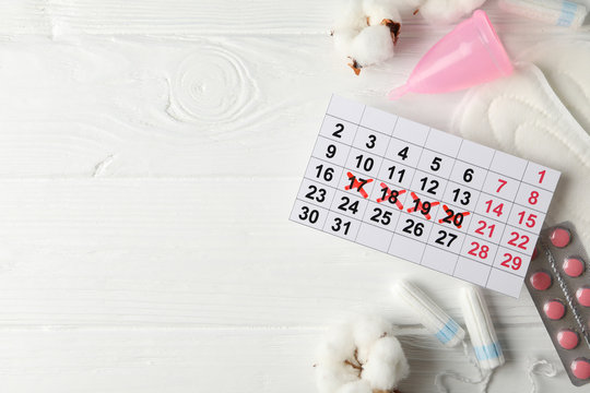 Menstruation period accessories on wooden background, space for text