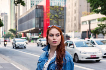 Fototapeta na wymiar Beautiful redhead woman at Paulista Avenue (Avenida Paulista), São Paulo, Brazil