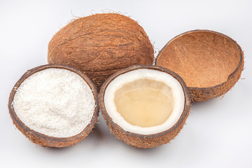 coconut halves with coconut, milk and pulp on a white background