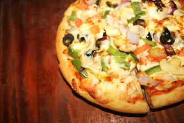 pizza with ham and mushrooms on wooden table