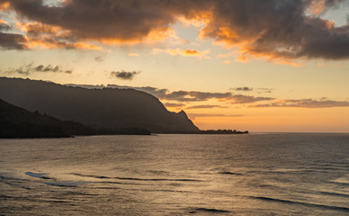 Sunset lights the clouds over the mountains called Bali Hai over Hanalei Bay in Kauai