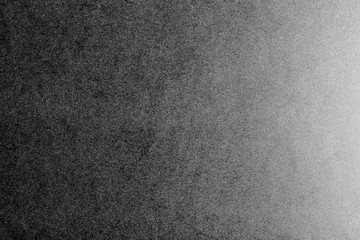 Black and white background made of real black paper with white dots, illuminated by a soft light from the right.