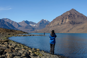 Traveller taking photo in Greenland at summer time © Alexey Seafarer
