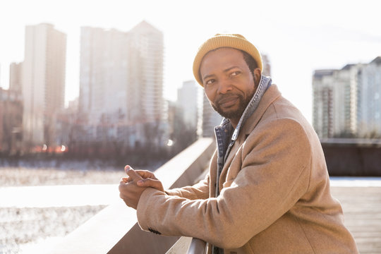 Man In Wool Coat And Knit Hat In Sunny City Park