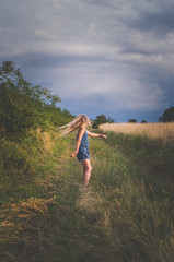 little child having fun in dramatic colorful scenic countryside