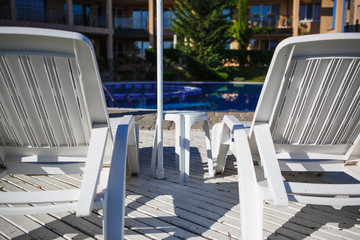 White plastic sun beds by the pool. Resort area in the hotel-relaxing by the pool