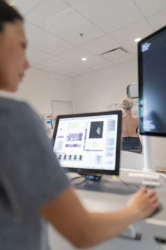Mammographer taking xray images at breast screening
