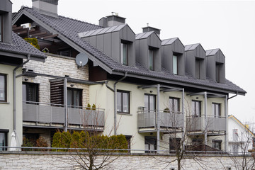 Facade of windows in attic or loft housing or office. Apartments under the roof in a modern house or cottage. Close-up of modern construction