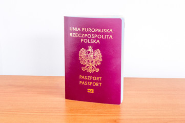Polish biometric passport on wooden table.