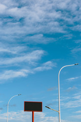 large advertising banner over blue sky with clouds, with the center cut to place your advertising