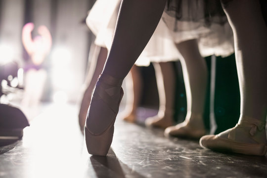 Close up female ballerina en pointe in ballet shoes off stage