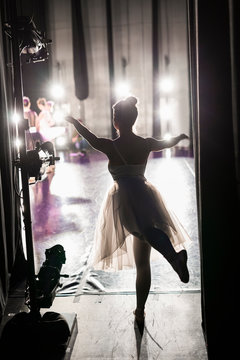 Silhouette graceful female ballerina practicing off stage