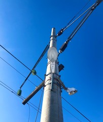 High pole with a lamp and electric wires 