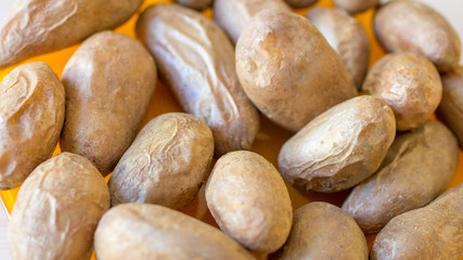 Whole baked potatoes in a peel closeup.