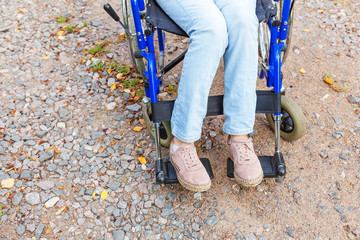 Legs feet handicap woman in wheelchair wheel on road in hospital park waiting for patient services....