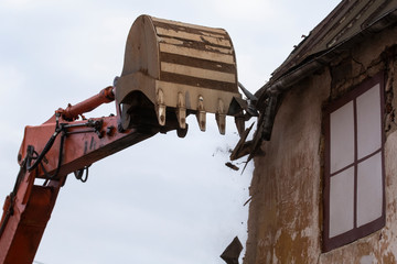 Building demolition. Construction machinery demolishes an old building