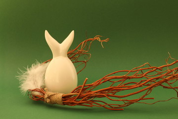 Weißes Ei mit Hasenohren, Weidenzweigen und weißer Feder