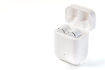  White Wireless Sport Headphones with Charging Box. Wireless in-ear Headphones for Jogging. Close Up View. Isolated on White Background.