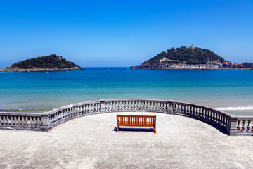 Fototapeta premium Boardwalk near La Concha beach overlooking Monte Igueldo and Santa Clara Island of the Bay of Biscay, San Sebastian, Donostia, Spain