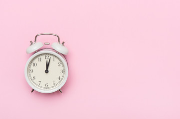 Retro alarm clock or vintage alarm clock isolated on pink background