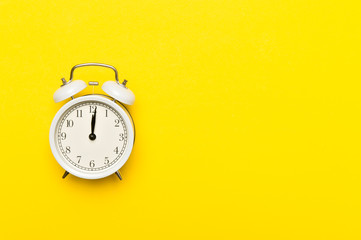 Retro alarm clock or vintage alarm clock isolated on yellow background